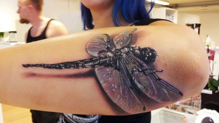 3D dragonfly on arm tattoo