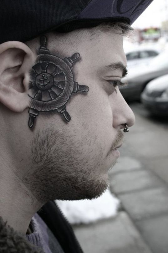 A ship's wheel face tattoo