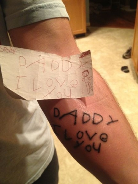 endearing child note on arm man tattoo