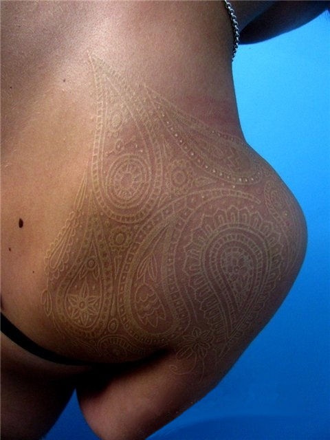 white ink tattoo on a shoulder