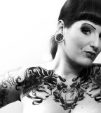 black and white photo girl with piercings chest tattoo