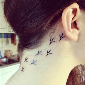 behind ear tattoo bird footprints