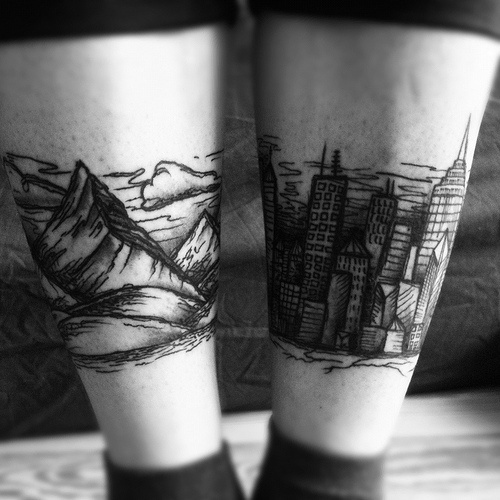 leg tattoo mountains and city