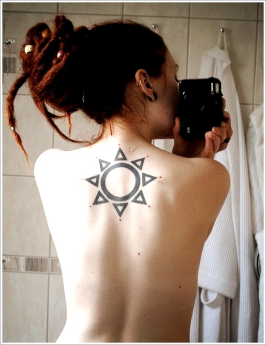 sun tattoo black work on upper back red hair