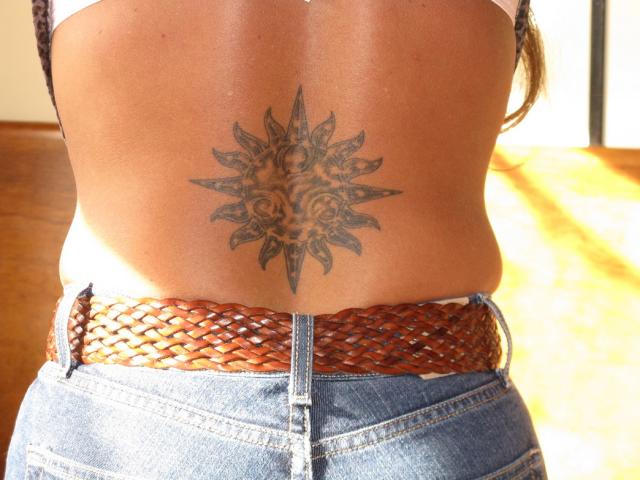 sun tattoo on the lower back