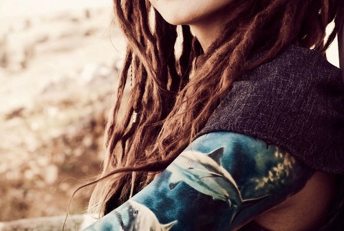 tattooed girl with dreadlocks blue arm tattoo sharks