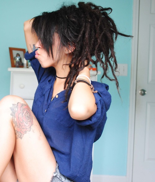 tattooed girl with dreadlocks blue shirts rose on leg