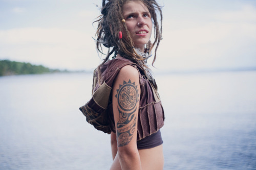 tattooed girl with dreadlocks near water