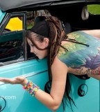 tattooed girl with dreadlocks rainbow wings blue car