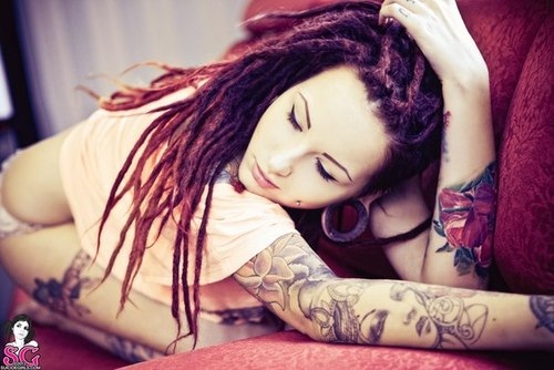 tattooed girl with dreadlocks red hair on couch