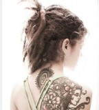 tattooed girl with dreadlocks shoulder tattoo flowers face