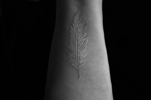 wrist tattoo white ink feather