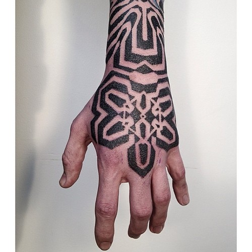 hand and arm blackwork tattoo by victor j webster