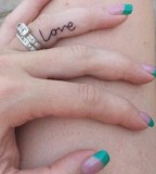 Love tattoo on ring finger