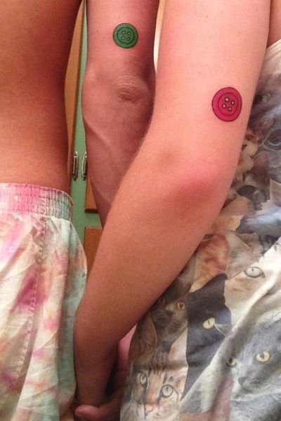 green tattoo buttons on arms for couple