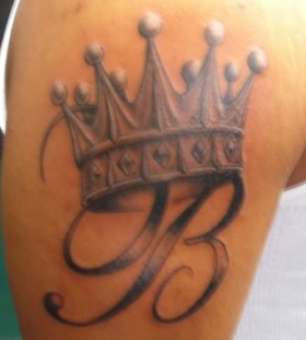 Letter and crown tattoo