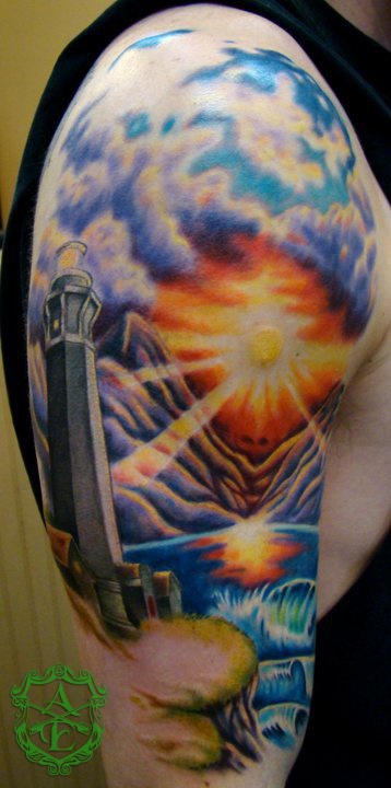 Lighthouse with sunset tattoo by Sean Ambrose