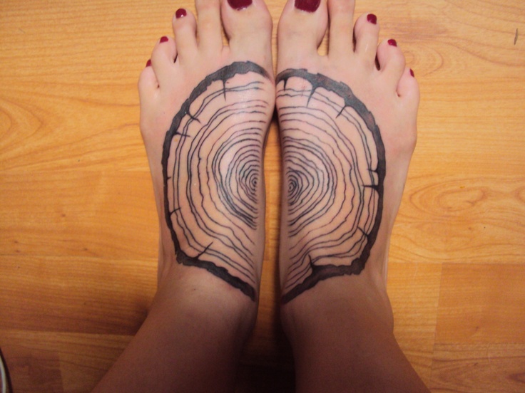 black ink wood tattoo on feet