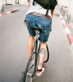 Adorable black bicycle tattoo on leg