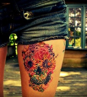 Adorable flowers and skull tattoo on leg