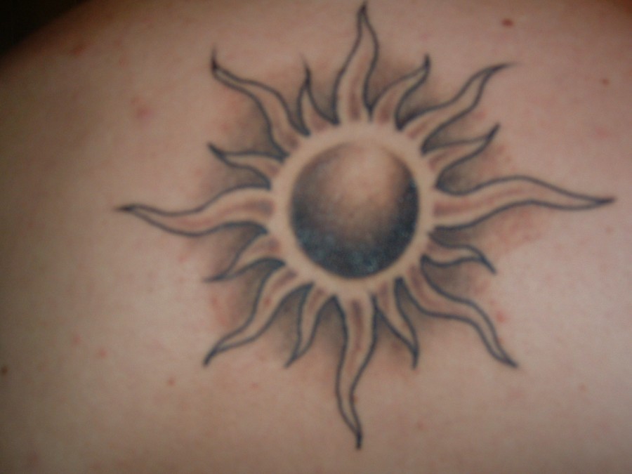 Artistic black sun tattoo on arm