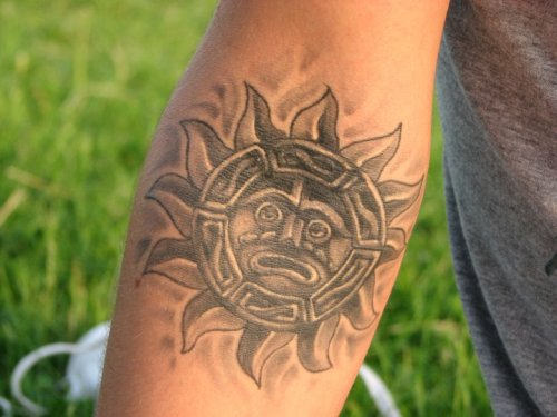 Aztec style sun tattoo on arm