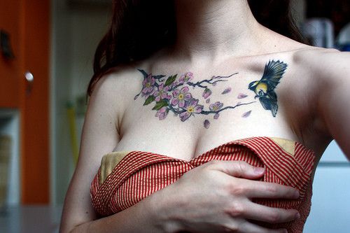 Bird and purple flower tattoo on chest