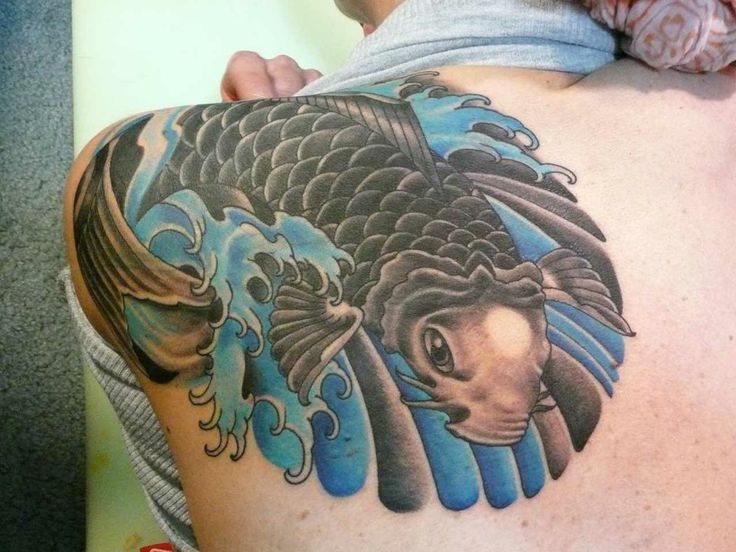 Black and blue fish tattoo on arm