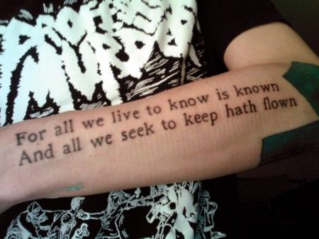 Black arm quote tattoo on arm