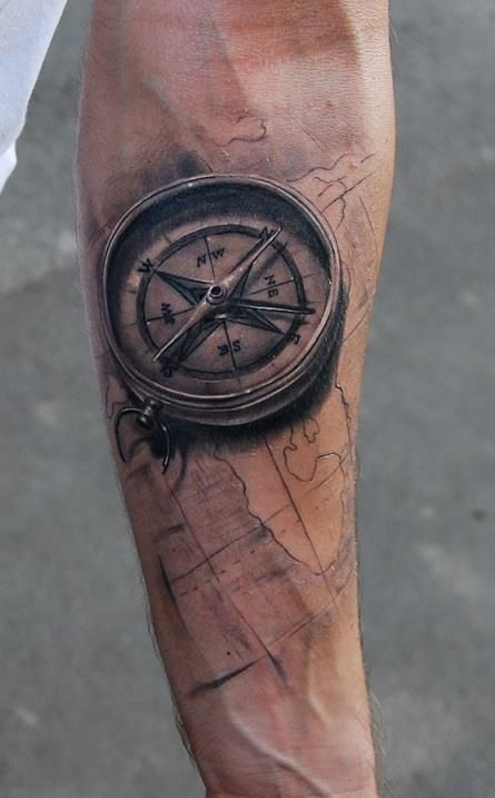 Black compass and map tattoo on arm