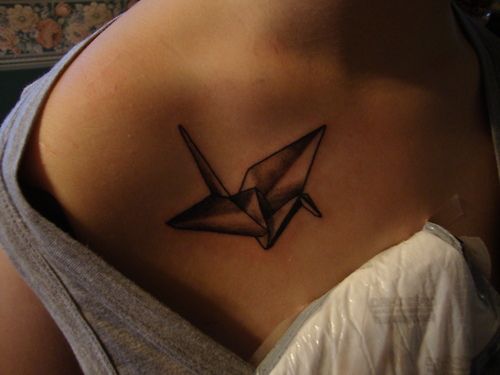 Black crane origami tattoo on shoulder