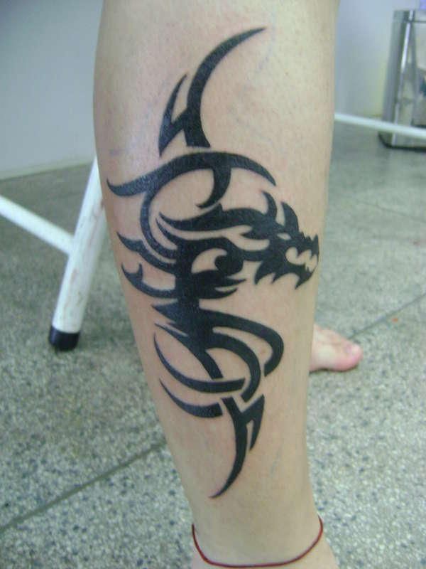 Black dragon tribal tattoo on leg