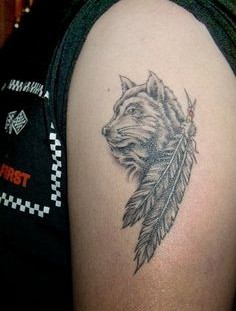 Black feather and wolf tattoo on arm