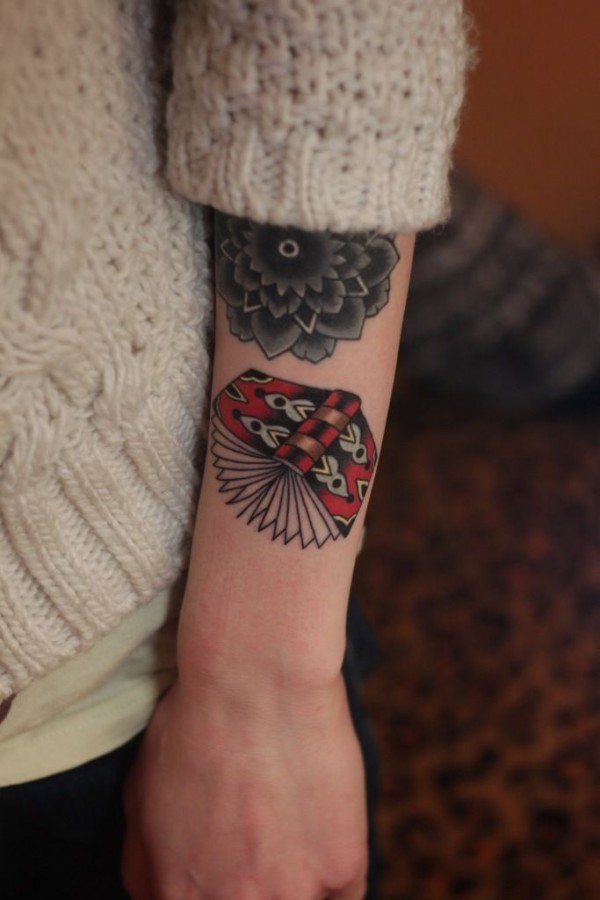 Black flower and book tattoo on arm