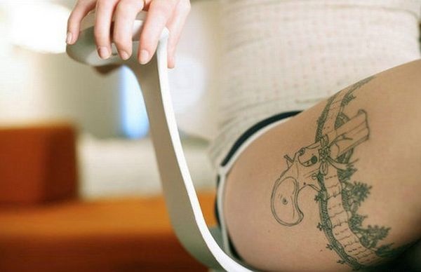 Black gun and lace tattoo on leg