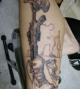 Black gun's and soldier tattoo on arm