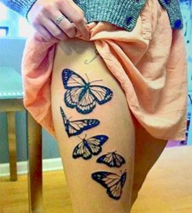 Black leg butterfly tattoo on arm