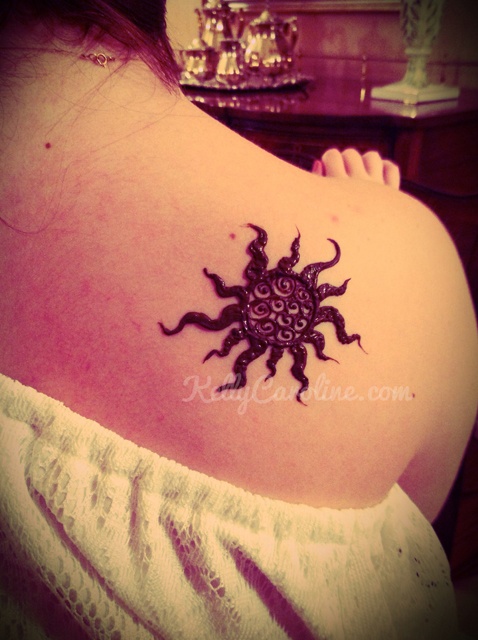 Black lovely sun tattoo on shoulder