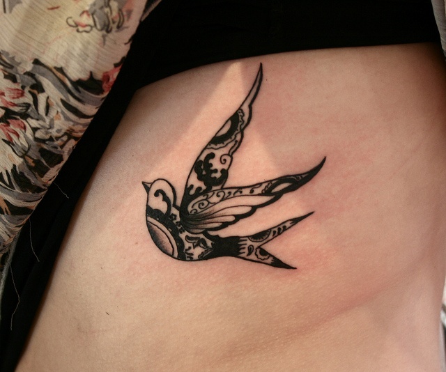 Black ornaments and bird tattoo