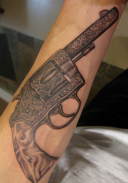 Black ornaments and gun tattoo