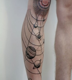 Black ornaments of sun tattoo on leg