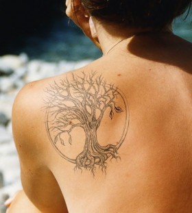 Black owal tree tattoo on shoulder