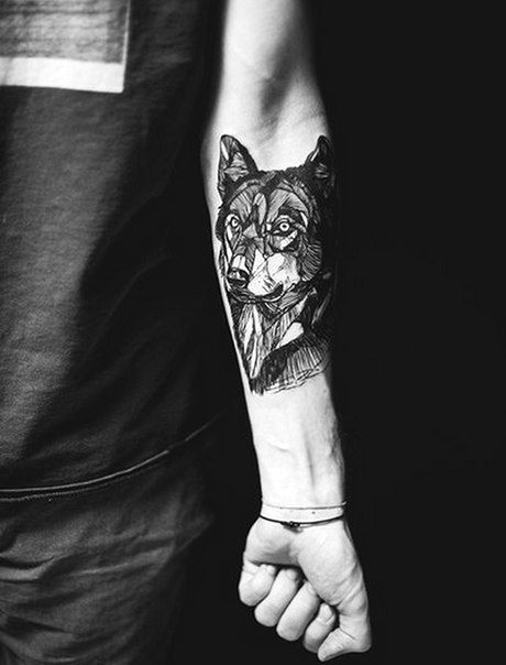 Black painted wolf tattoo on arm