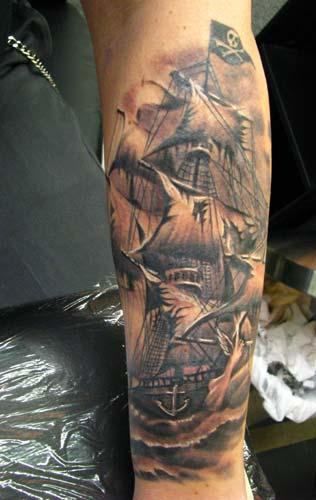 Black pirates ship tattoo on arm