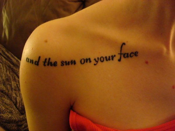 Black quote sun tattoo on shoulder