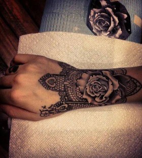Black rose and lace tattoo on arm