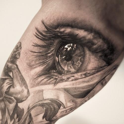 Black sculpture and eye tattoo on arm