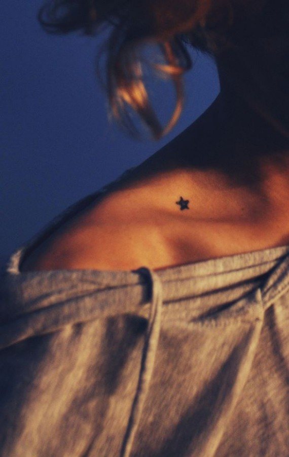 Black small star tattoo on shoulder