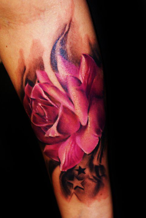 Black stars and pink rose tattoo on arm