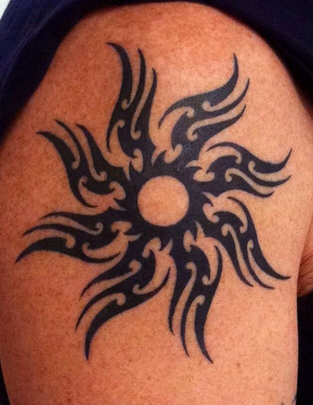 Black tribal sun tattoo on shoulder